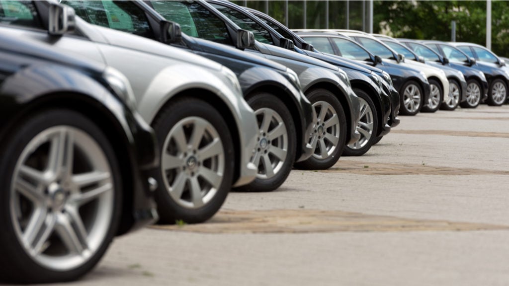An angled side view of a row of parked cars.