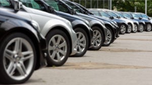 An angled side view of a row of parked cars. automotive stock picks. Industries Set to Dominate Second Half of 2024