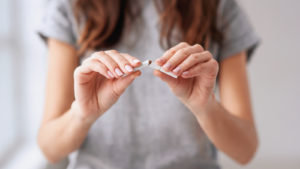 Image of a woman breaking a cigarette in half
