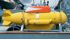 A bright yellow unmanned underwater vehicle on a ship.