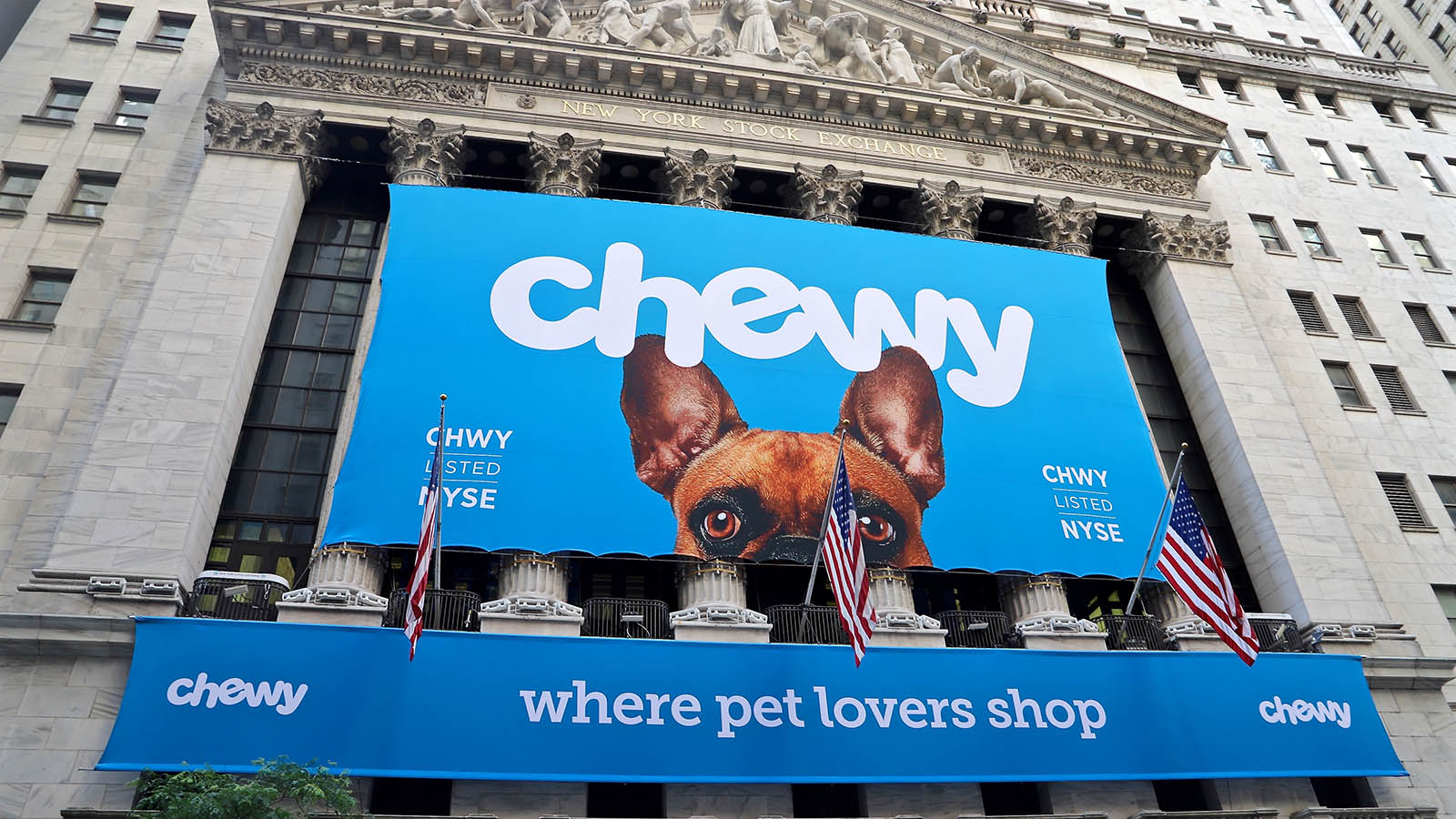 CHWY Stock. The Chewy logo on a banner at the New York Stock Exchange.