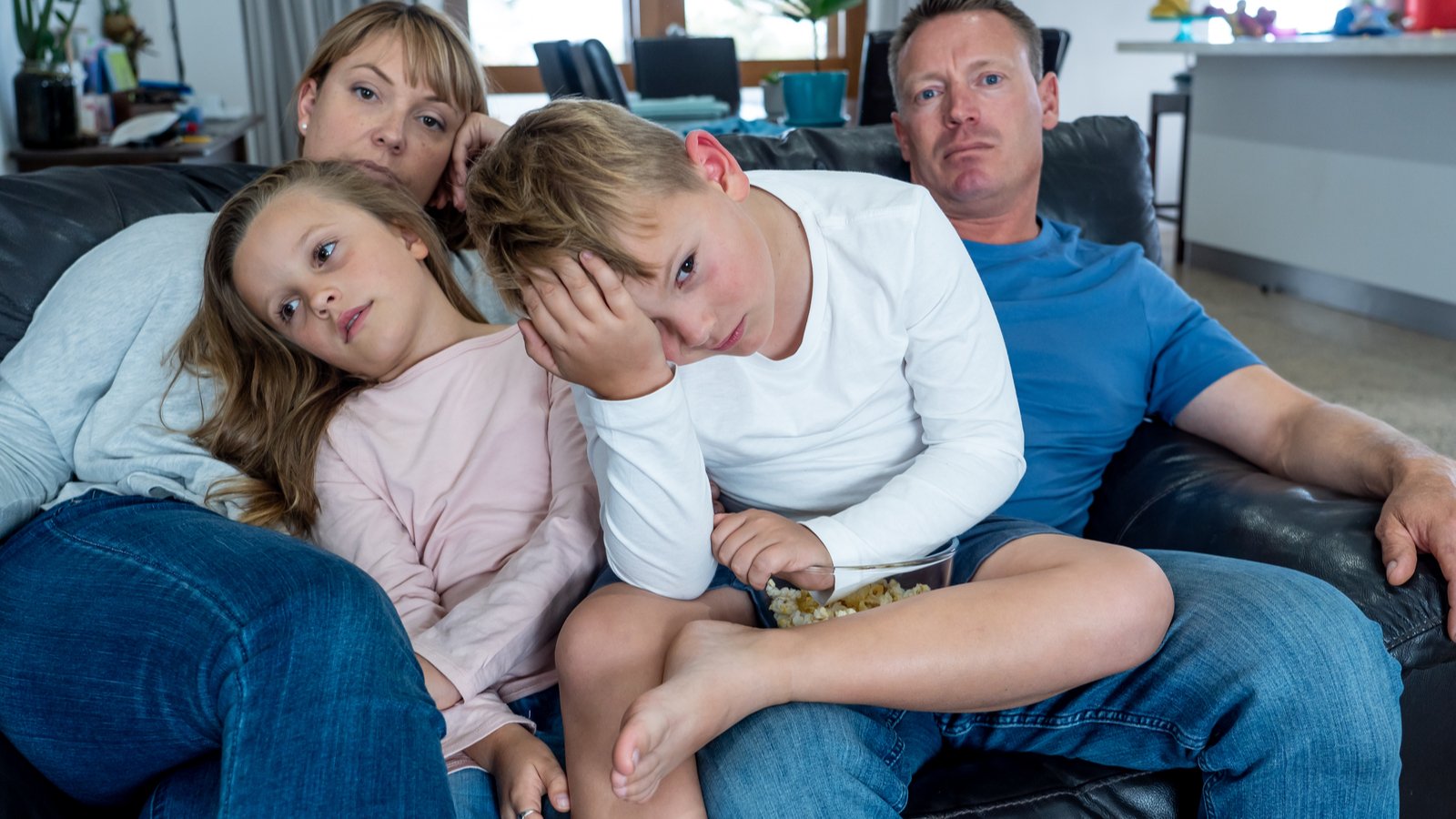 Family of four looking sad during lockdown representing veru stock.