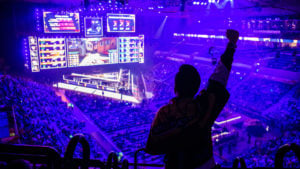 a fan holding up their hand in a live, esports arena