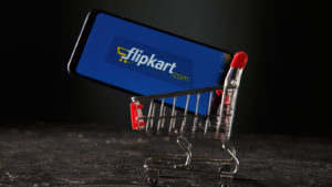 Image of the Flipkart logo on a smartphone sitting in a small shopping kart representing IPO news.