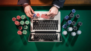 Image of a laptop surrounded by gambling paraphernalia.