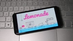 Lemonade stock logo displayed on smartphone laying on top of computer keyboard.