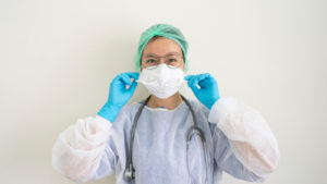 a medical professional putting on PPE
