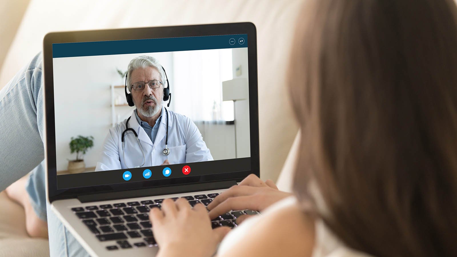 A woman talks to a doctor on her laptop. telehealth stocks