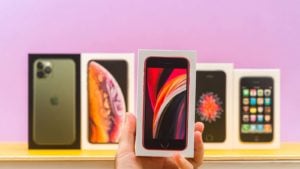 Earnings reports: A close-up shot of different Apple (AAPL) iPhones in front of a purple background.