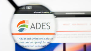 Advanced Emissions Solutions (ADES) website under a magnifying glass.