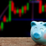Smiling piggy bank against stock chart background. Represents cheap stocks and stocks selling at a discount. stocks under $20. Cheap Growth Stocks