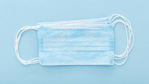 A stack of disposable face masks rests on a blue background, representing WORX stock.