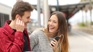 Image of a couple sharing headphones listening to music