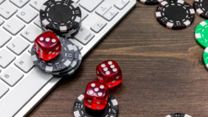 poker chips and dice on top of a keyboard representing gambling stocks