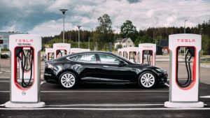 A black Tesla (TSLA) Model S is parked between rows of charging stations.