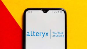 The Alteryx (AYX) logo is displayed on a smartphone screen.