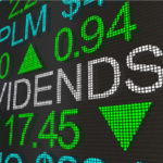 stock market ticker screen with the word "dividends" appearing in large text