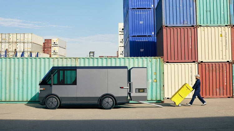 A Canoo MPDV being loaded with small shipping containers