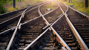 A photo of train tracks leading toward a sunset.