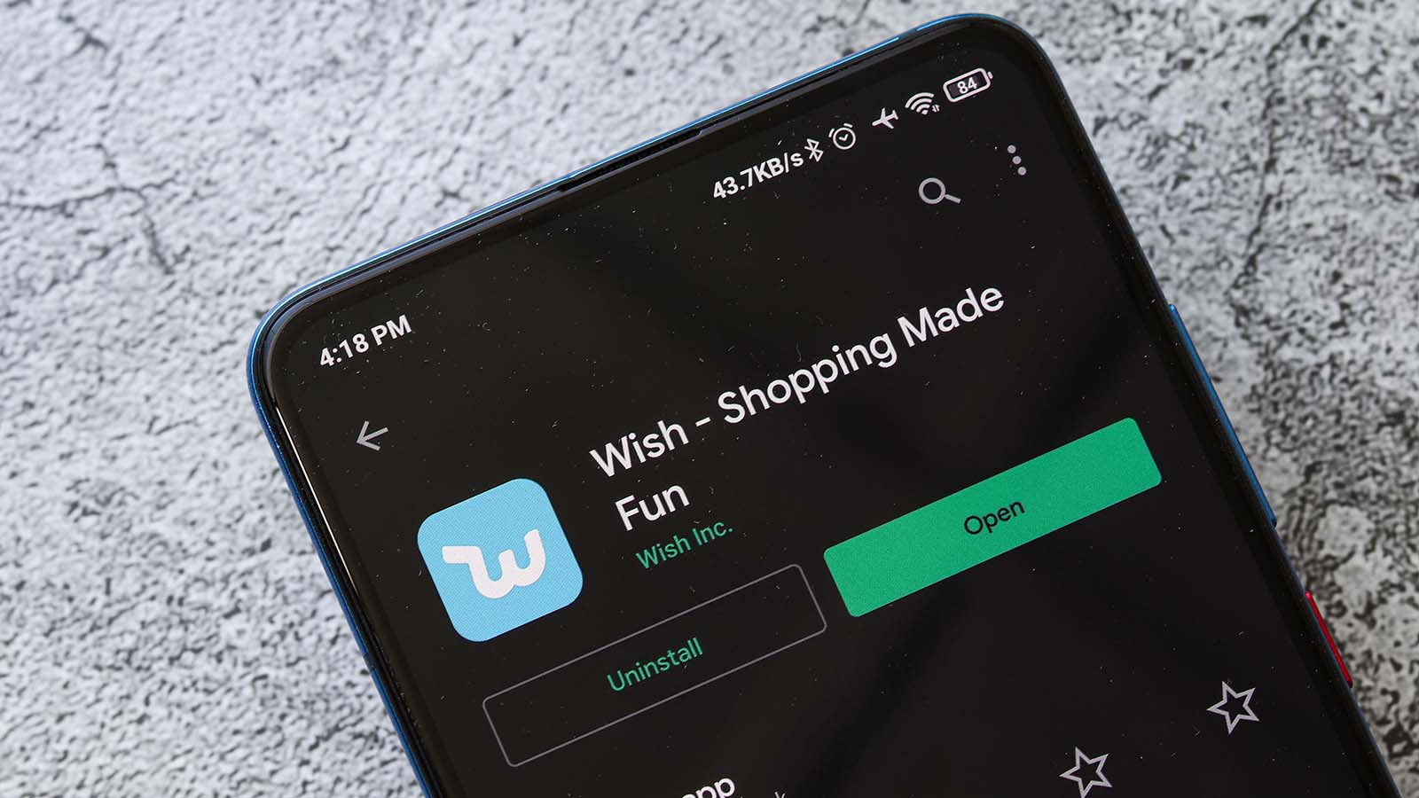 The logo and information for the Wish (WISH stock) mobile app are displayed on a smartphone.