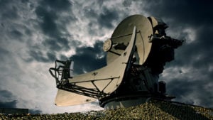 Large satellite against a backlit cloudy sky