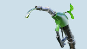 An image of a gas pump nozzle with gasoline or biofuel drop and growing green sprout