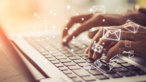 Image of a woman typing an email.