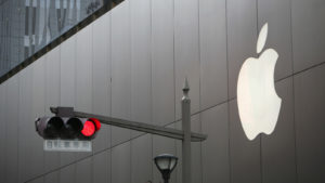 Apple logo seen on building next to traffic light.