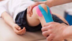 child with knee brace in a physical therapy session