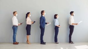 A line of people holding resumes, as if at a staffing agency.