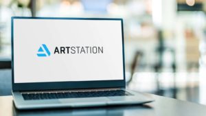 A laptop screen displays the logo for ArtStation.