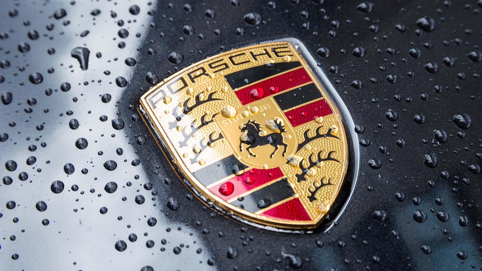 The Porsche logo on a black vehicle.