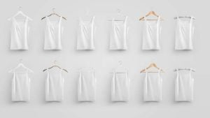 White undergarments hang on wooden hangers against a white background.