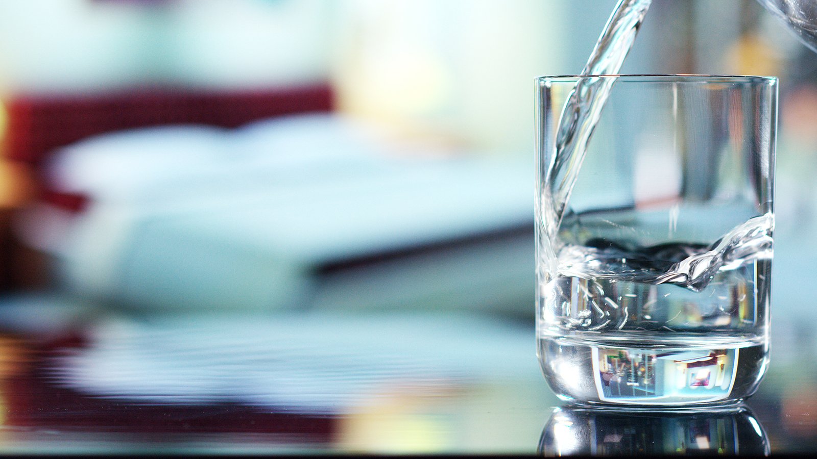 Distilled Water Shortage 2023. A photo of water being poured into a glass that's sitting on a table.