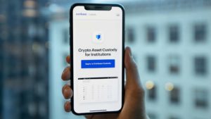 A hand holds a close-up look at the Coinbase (COIN) platform.