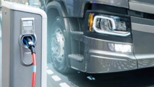 An electric semi truck charging representing Atlis Motors IPO.