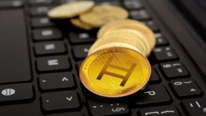 Fichas conceptuales para Hedera Hashgraph (HBAR) en un teclado negro.