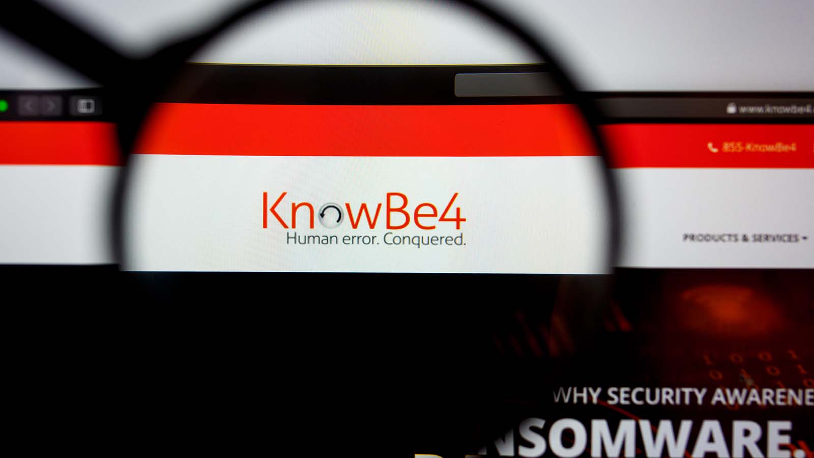 A magnifying glass zooms in on the website for KnowBe4 (KNBE stock).