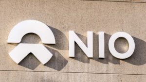 A Nio (NIO stock) sign and logo on a tan concrete building.