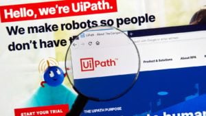 A magnifying glass zooming in on the home page of the UiPath (PATH) website.