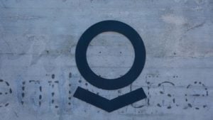 Le logo Palantir (PLTR) sur un mur gris.