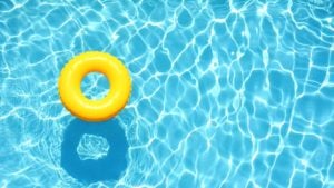 Yellow pool float, ring floating in refreshing blue pool