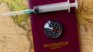 The concept image of a vaccine passport with a needle and map.