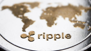 A close-up shot of an XRP token with the logo and Ripple in raised text. XRP price predictions.