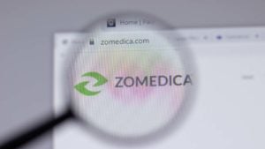 A magnifying glass zooms in on the website for Zomedica (ZOM).