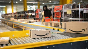 Logistics activities at the Amazon (AMZN) site in Verizy-Villacoubray, France. Baggage is sorted by workers on a conveyor.