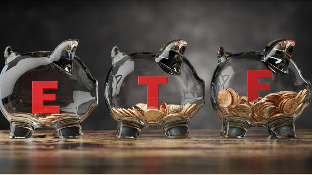 An image of three glass piggy banks with ETF written on the sides on a table.