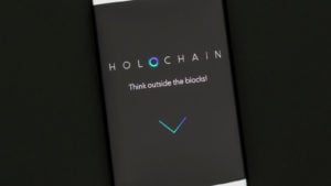 Holo crypto: Holochain website displayed on smartphone screen.