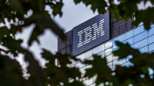 樹冠越しに見たIBM（IBM）の建物の写真。 建物の側面に大きな文字でIBMのロゴが入っています。