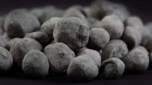 A pile of iron ore granules on a black background.